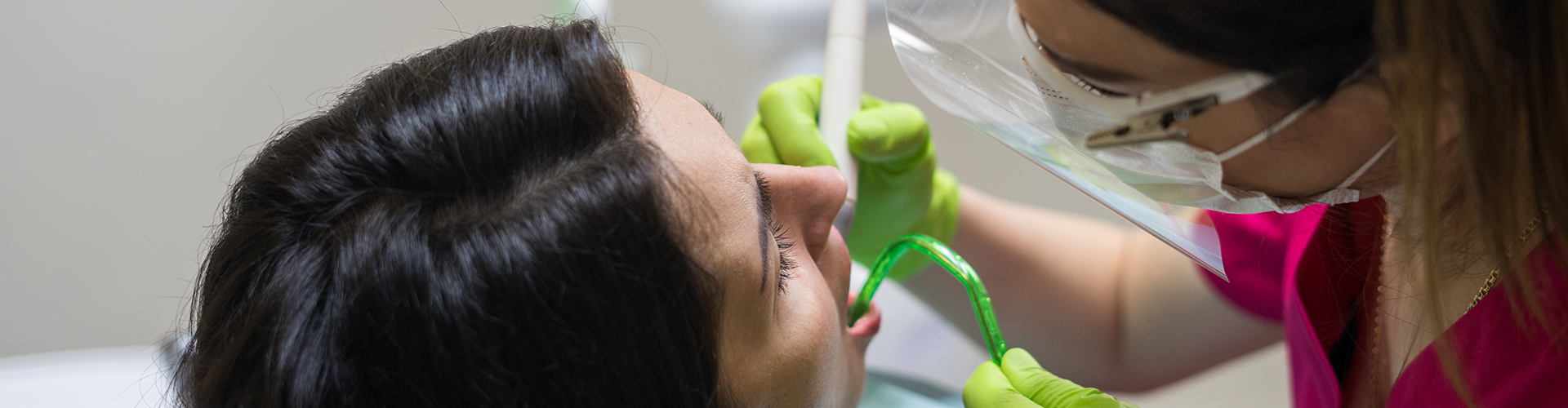 dentist using dental tools in woman's mouth